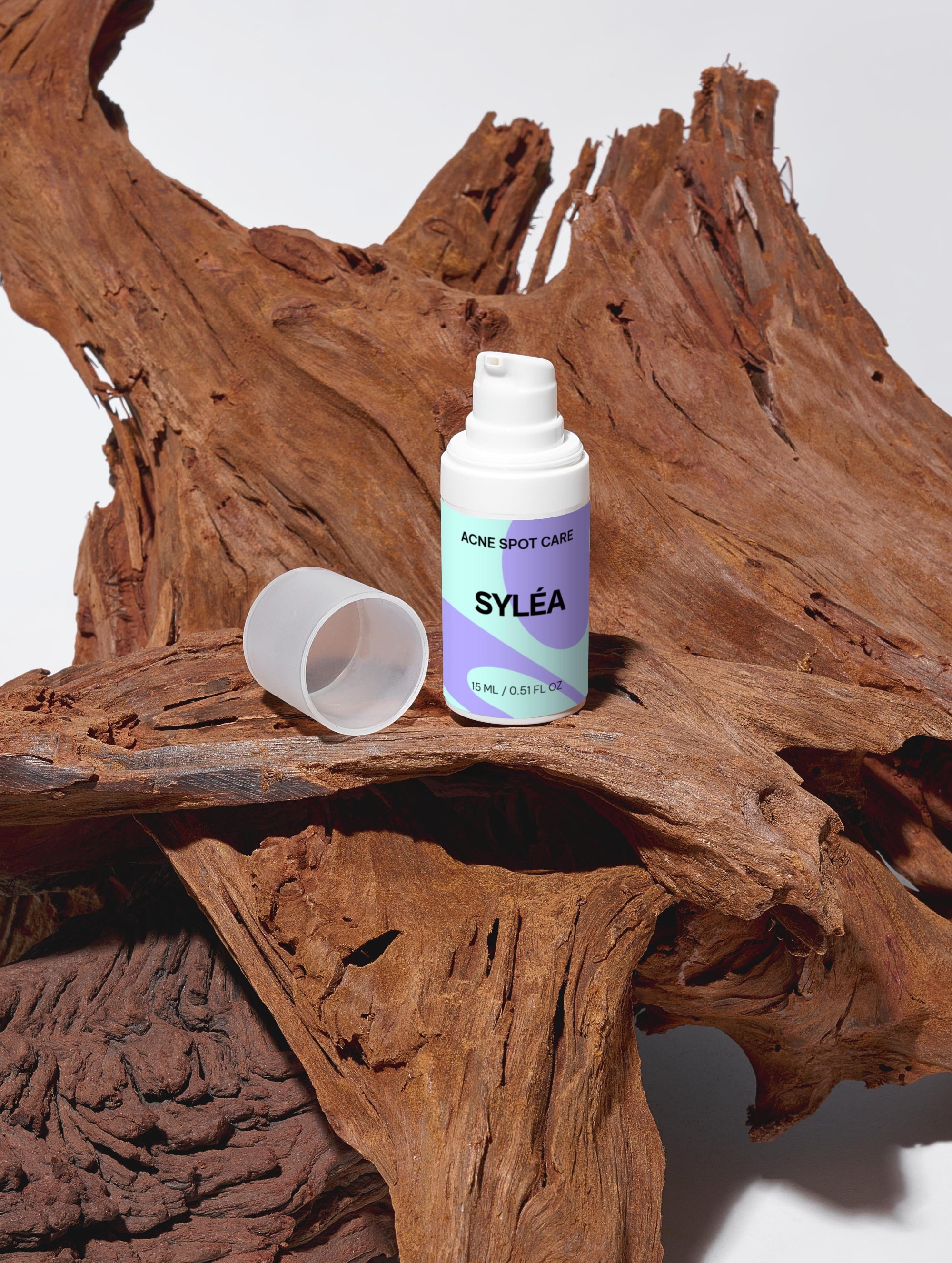 SYLÉA Acne Spot Care serum bottle on natural wooden surface for acne-prone skin